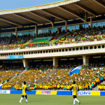 가봉 축구 리그와 대표팀 - **

"A vibrant stadium scene in Libreville, Gabon during a national league match. Players in colorfu...